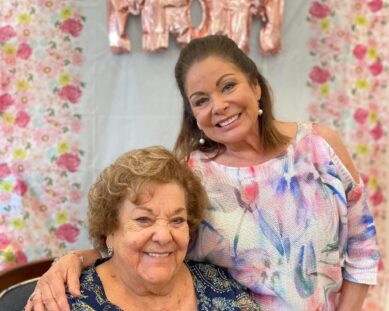 Mother and daughter smiling in front of 